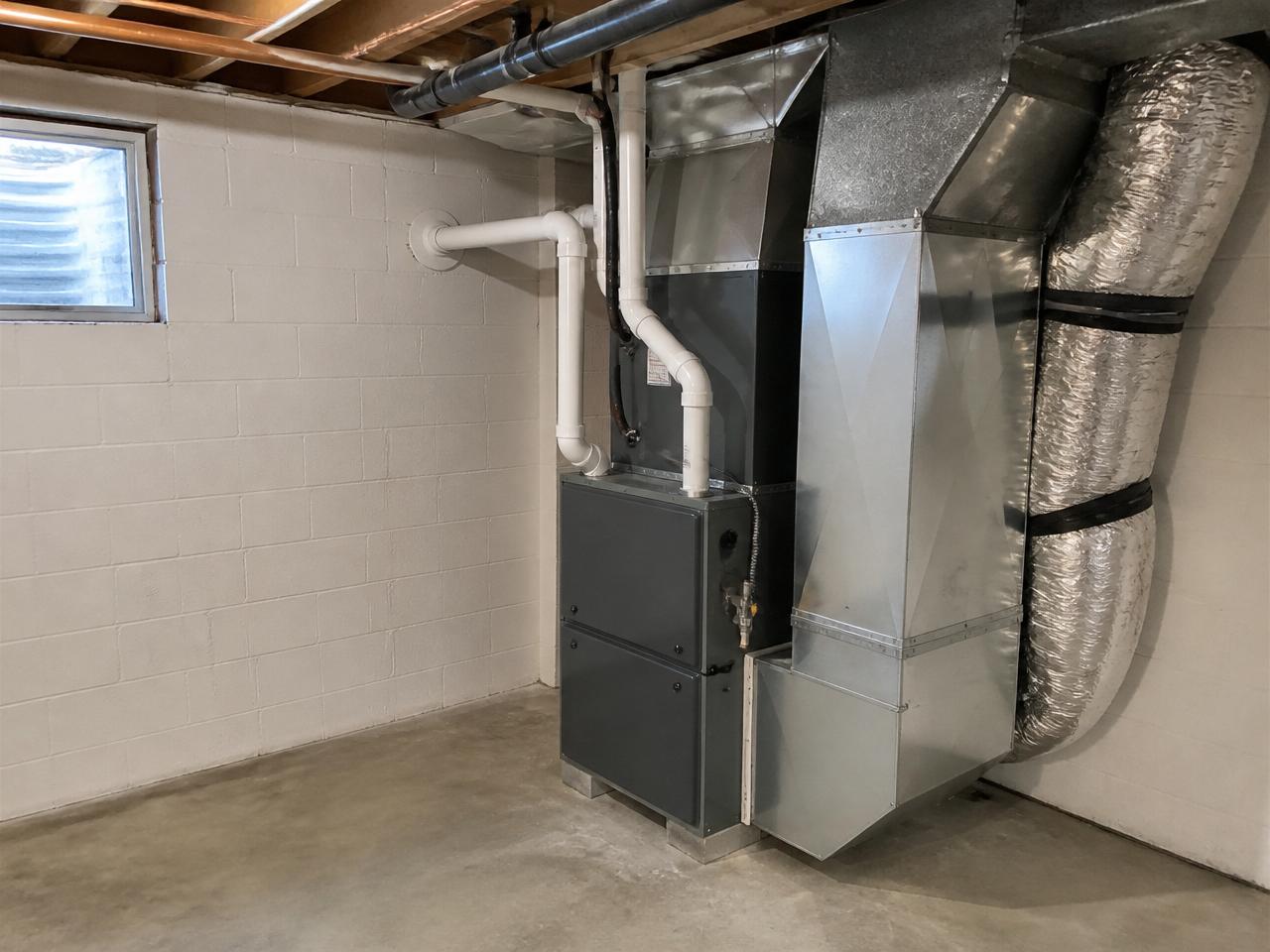 After: Same-location after: new furnace and air handler installed in the same corner with tidy ductwork